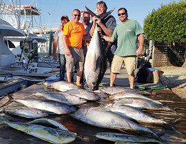 Group holding HUGE tuna caught aboard the Carly A Outer Banks fishing charter.